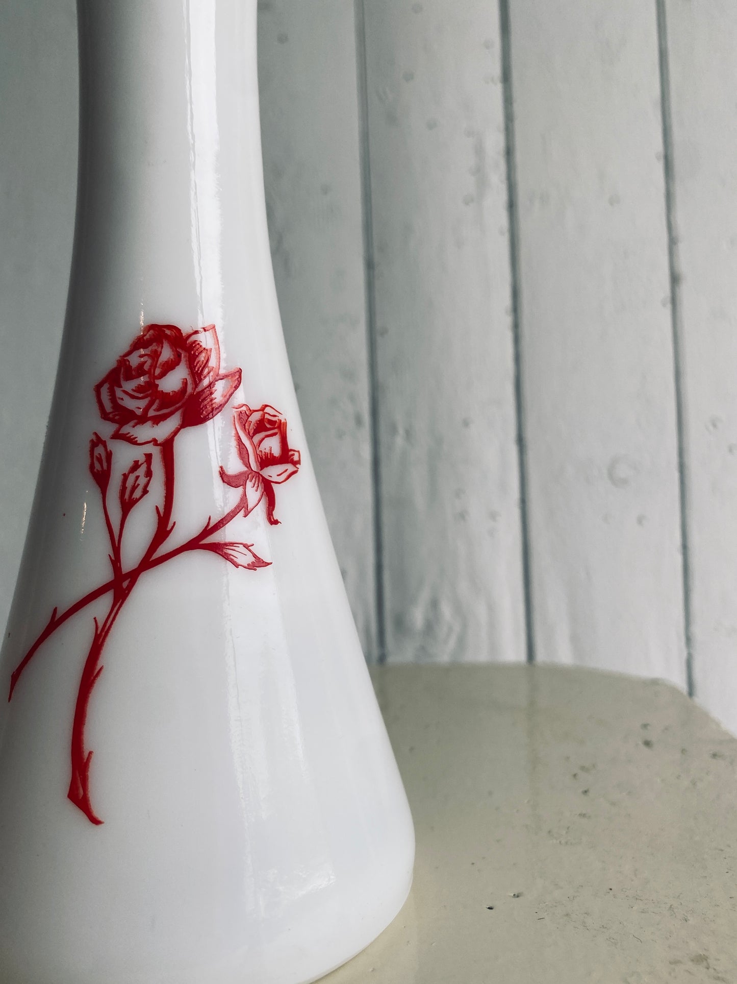 Vase de verre blanc et ses fleurs rouges